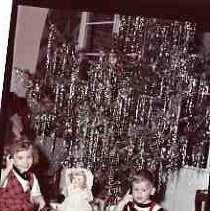 Children sitting under a Christmas tree
