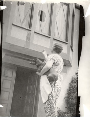 [Unidentified woman pointing to damage done to her home during longshoremen's strike]