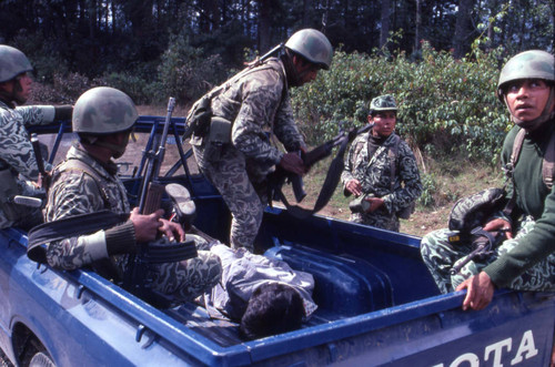Soldiers and a hogtied man, Guatemala, 1982