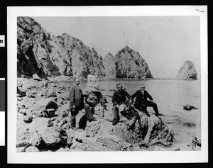 Portrait of four people posed near the Sugar Loaf rock formation on Catalina Island, July 4, 1900
