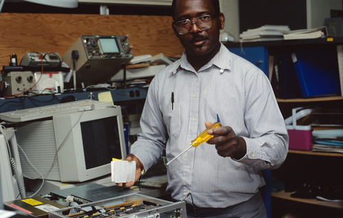 Balumbu "Bal" Kimbembe standing with computer equipment