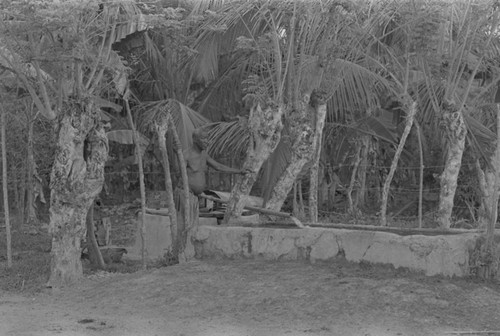 Man standing next to water flowing from a pipe, San Basilio de Palenque, ca. 1978