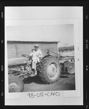 Tom Moriyama and son Craig on a tractor on the family farm in Del Rey