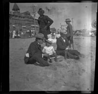 H. H. West sits on the beach with Lester Shaw and William Shaw, Santa Monica, 1901