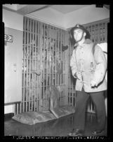 Fireman walking past crowded jail cell during prisoner's riot at Los Angeles County Jail, Calif., 1953