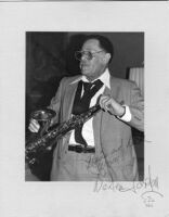 Autographed photo of Dexter Gordon with saxophone, 1979 [descriptive]