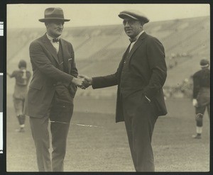 University of Southern California athletic director Bill Hunter and head football coach "Gloomy Gus" Henderson shaking hands on the football field at Los Angeles Coliseum, 1923