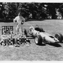 Woody Harris (race car driver) will try for European "hardware." He is shown with many of his trophies and ribbons, and his race car
