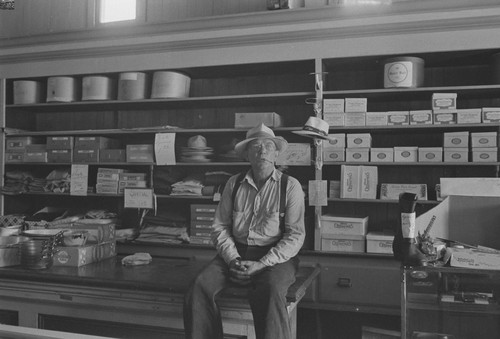 Customer sitting on counter of McKenzie Store, Monticello, Berryessa Valley