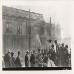 Crowd gathered to witness burning commercial building at 23rd Avenue and East 12th Street, along the Western Pacific tracks in Oakland, California
