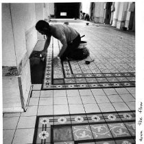 A worker is laying down decorative tile to the hall floor of the California State Capitol building as part of the restoration of the building