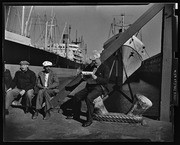 Men sitting on waterfront dock, California Labor School