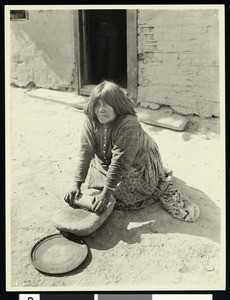 Portrait of a Native American woman grinding corn, ca.1900