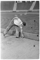 Sports official retrieving the shot at a track meet between UCLA and USC, Los Angeles, 1937