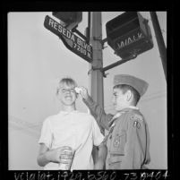 Boy Scout wiping the eyes of girl during smog alert in Reseda, Calif., 1965