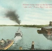 Steamer towing barge up the Sacramento River laden with "Phoenix Flour" and other goods