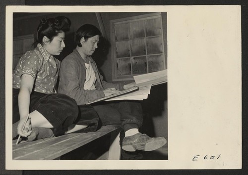 Benji Okuda, well known artist of Japanese ancestry, sketches a few pointers for a student in an adult art class at the Heart Mountain Relocation Center. Photographer: Parker, Tom Heart Mountain, Wyoming