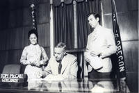 Patricia Whiting beside Governor Tom McCall as he signs a bill