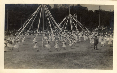 Children weave streamers around a may pole during the second annual May Day celebrations in Kentfield, California, May, 1910 [photograph]