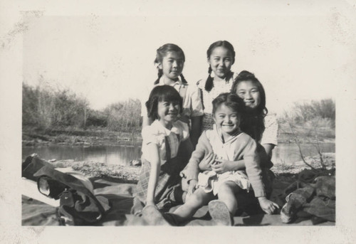 Five young girls posing by a river near Poston incarceration camp