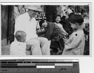 A Maryknoll priest with orphans at Luoding, China, 1936