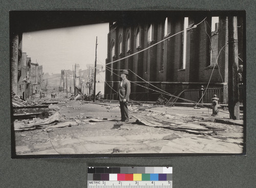 [Man amid rubble at intersection of Dupont St. (Grant Ave.) and California St. Ruins of St. Mary's Church, right.]