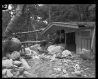 Flood waters rush past a damaged cabin in Little Santa Anita Canyon, Sierra Madre, 1926