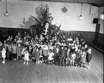 Group photograph of children standing in front of Christmas display