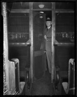Deputy US Marshal John P. Brooke stands in the door of a railway prison car, Los Angeles, 1935