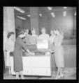 Four women around a GE electric range on display