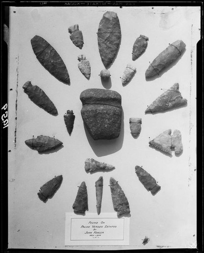 Display of mounted Indian artifacts including arrowheads and stones, Palos Verdes Estates, 1930 or 1931