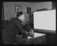Deputy United States Marshal Eugene Danz using a projection machine to show a sixteen-millimeter film, Los Angeles, 1935