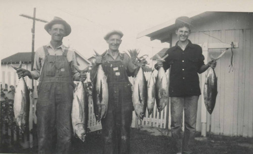 Sam Hennig, Willie Hennig, and Jack Huber holding fish in Huntington Beach, 1940