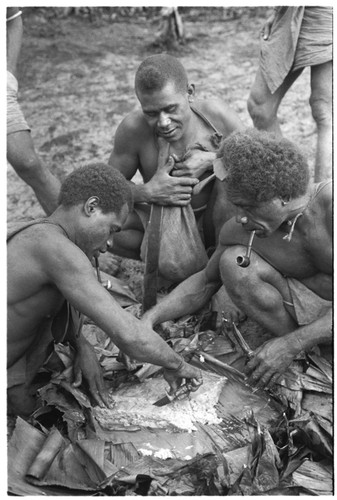 Men eating gwasu taro and coconut pudding