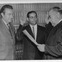 Edward J. Garcia. Caption reads, "Edward Garcia, center, was sworn in today as chief deputy district attorney by Municipal Court Judge Albert H. Mundt, right
