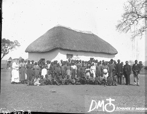 Group of African people in front of a building with a thatched roof, Limpopo, South Africa, ca. 1896-1911