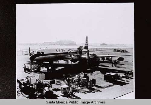 B.O.A.C. Douglas Aircraft Company DC-7 cargo plane on tarmac with equipment