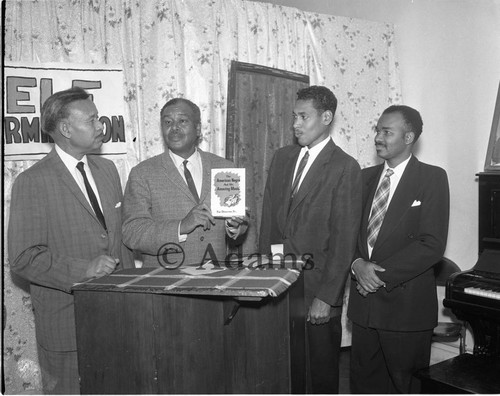 Four men with book, Los Angeles, 1965