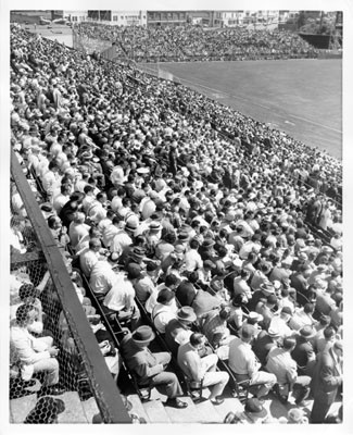 [Fans in the third base stands at Seals Stadium during the opening game of the 1958 season between the San Francisco Giants and the Los Angeles Dodgers]