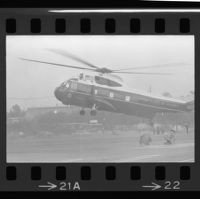 Firefighters duck as President Johnson arrives via helicopter at Century Plaza, 1967