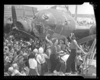 Women aircraft workers signing their names on the B-17 bomber, Memphis Belle in Long Beach, Calif