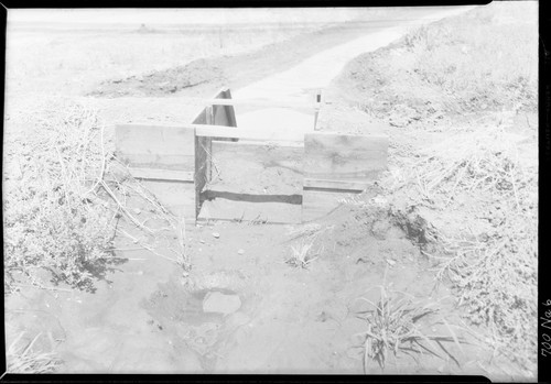 Small Redwood gate in field ditch. Width of box 2'6", depth 2'0". Single wing wall. Merced Irrigation District