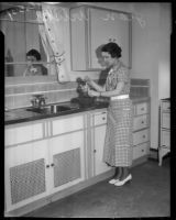 Jean Wilson uses a hand mixer in a kitchen, Los Angeles, 1930s