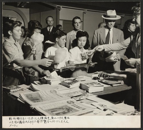 Americans All booth at Pan-Pacific Industrial Exposition, Los Angeles, sponsored by anti-racial civic organizations in cooperation with W.R.A. (Continuous motion picture showing of Nisei in Action and World We Want to Live In.) Photographer: Iwasaki, Hikaru Los Angeles, California