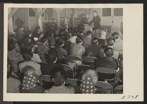 A block group of Japanese and Japanese-Americans, residents at the Granada Relocation Center, listen to an explanation of the army