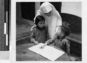 Maryknoll Sister teaches two children, Tsungkeou, Kaying, China, ca. 1940