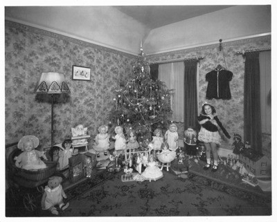 Christmas - Calif. - Stockton: Unidentified girl standing to the right of a Christmas tree and assorted toys