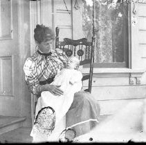 Woman posing for photograph with child on porch