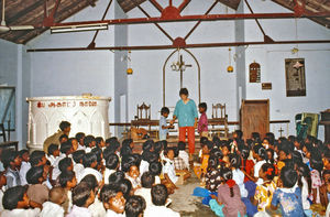 24.- Tamil Nadu, Indien, 1988-89. "Med 80 elever i klassen" - En dansk lærer i Arcot skoleprojekt fortæller: Så er der gang i undervisningen. Vi er rykket ind i kirken, fordi skolen endnu ikke har lokaler nok. Omvendt er det sådan, at i nogle landsbyer bliver skolen om søndagen brugt til gudstjeneste, fordi man ikke har nogen kirke