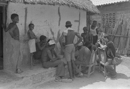 Nina S. de Friedemann and Richard Cross watch men playing a game, San Basilio de Palenque, ca. 1978